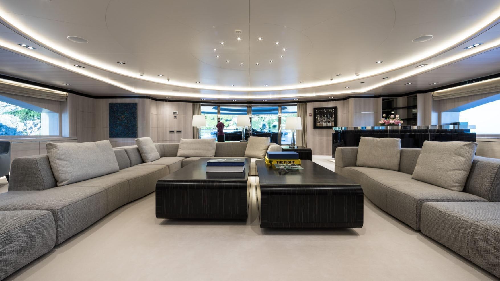 a large living room with a large sofa and a table aboard O'PTASIA Yacht for Charter