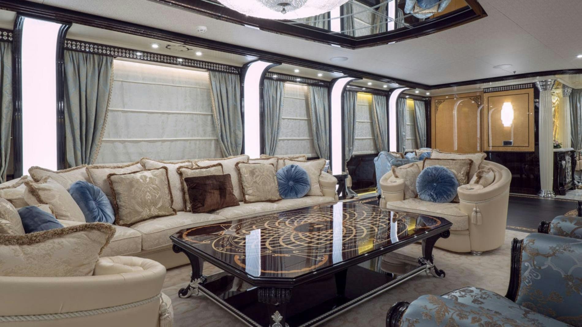 a living room with a large sofa and a coffee table aboard ELEMENTS Yacht for Charter