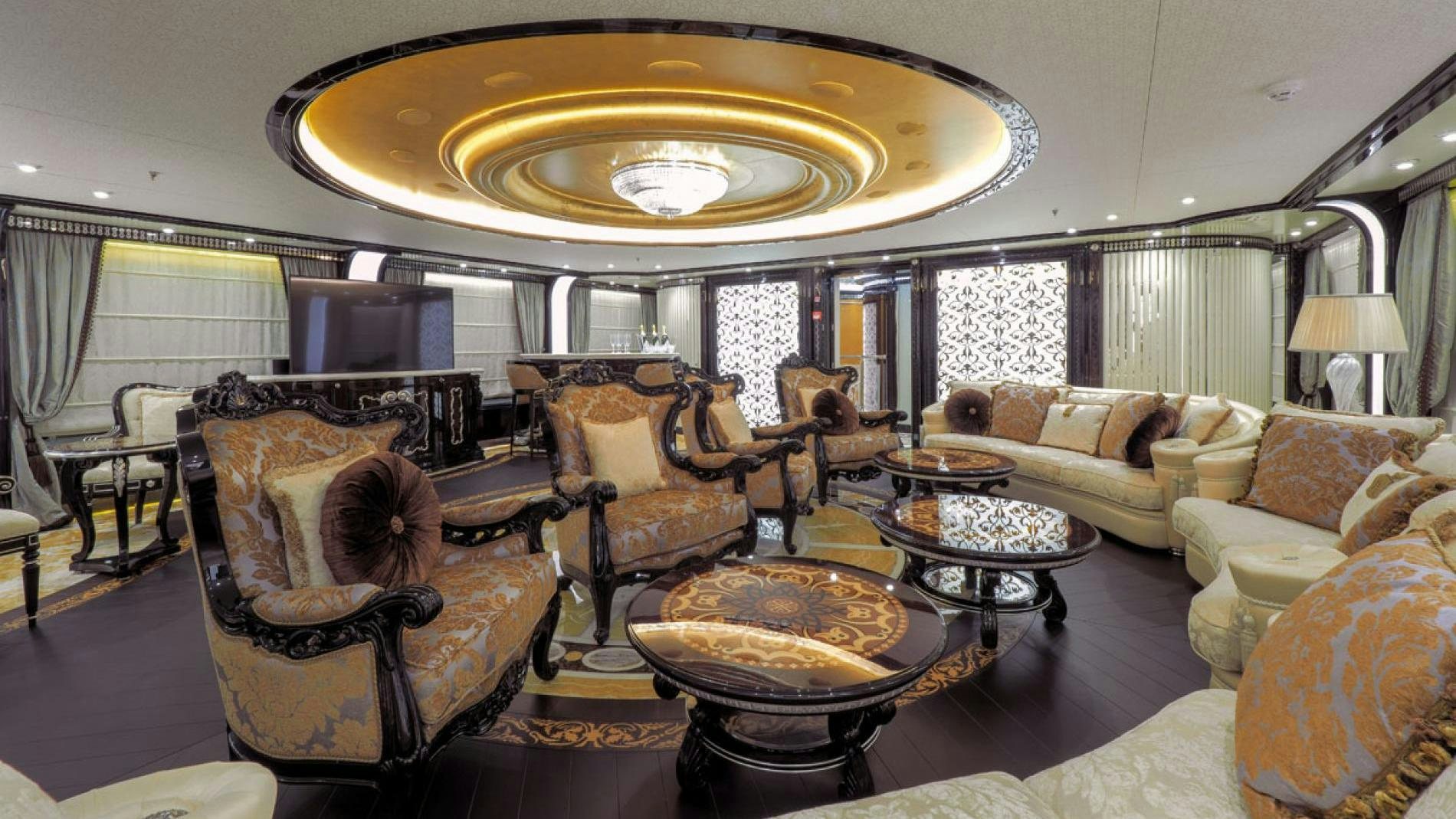 a large living room with a chandelier aboard ELEMENTS Yacht for Charter