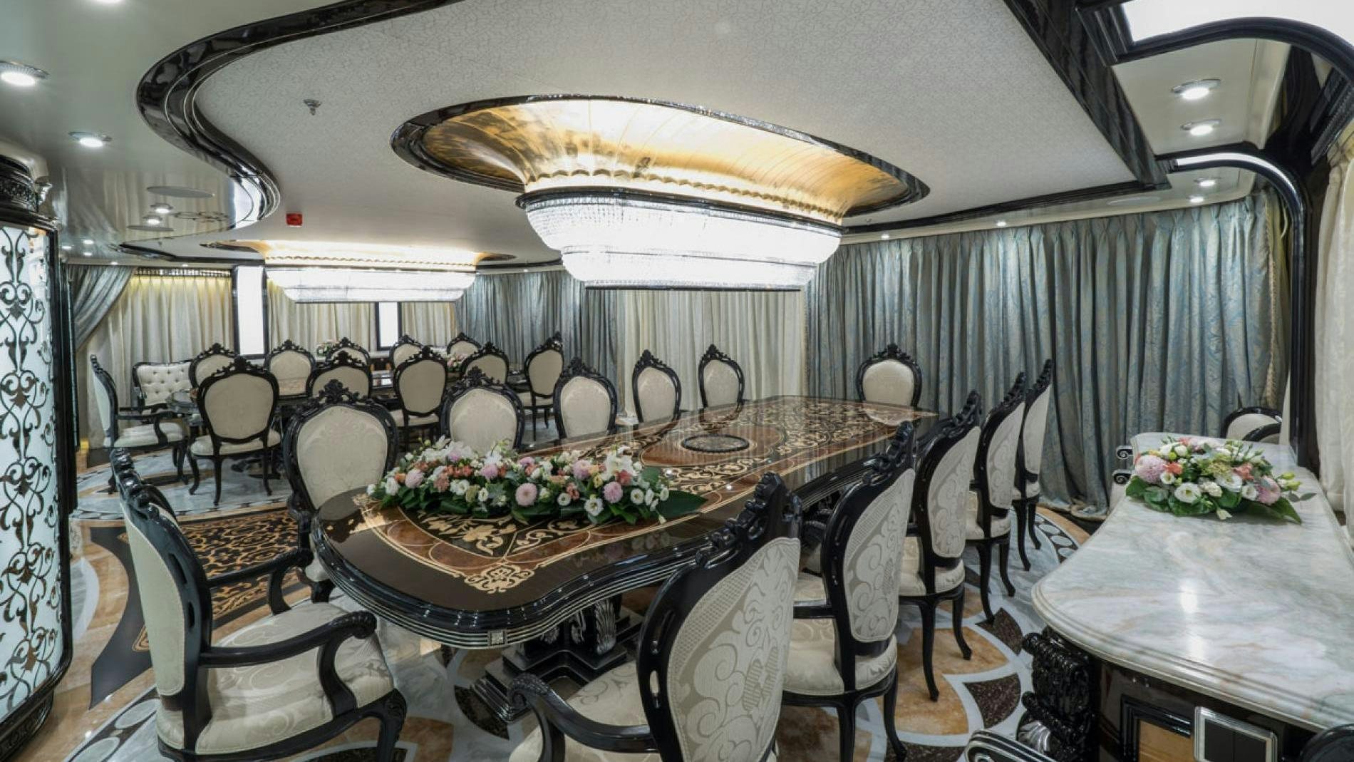 a dining room with a table set for a wedding aboard ELEMENTS Yacht for Charter