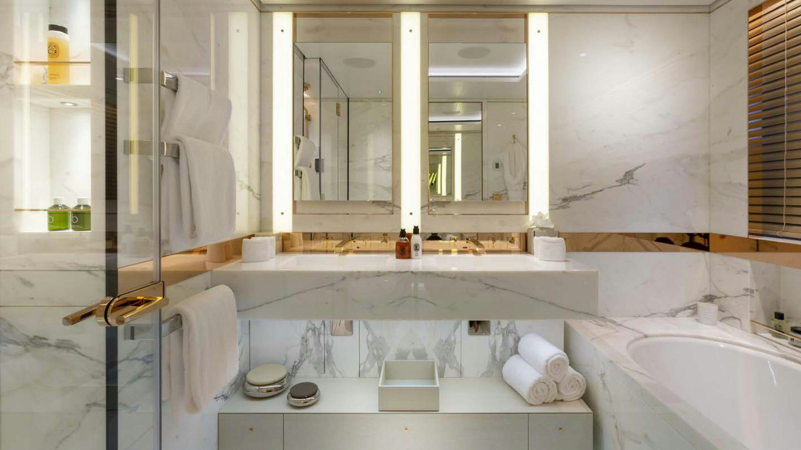 a bathroom with a tub sink and a mirror aboard LUNASEA Yacht for Charter