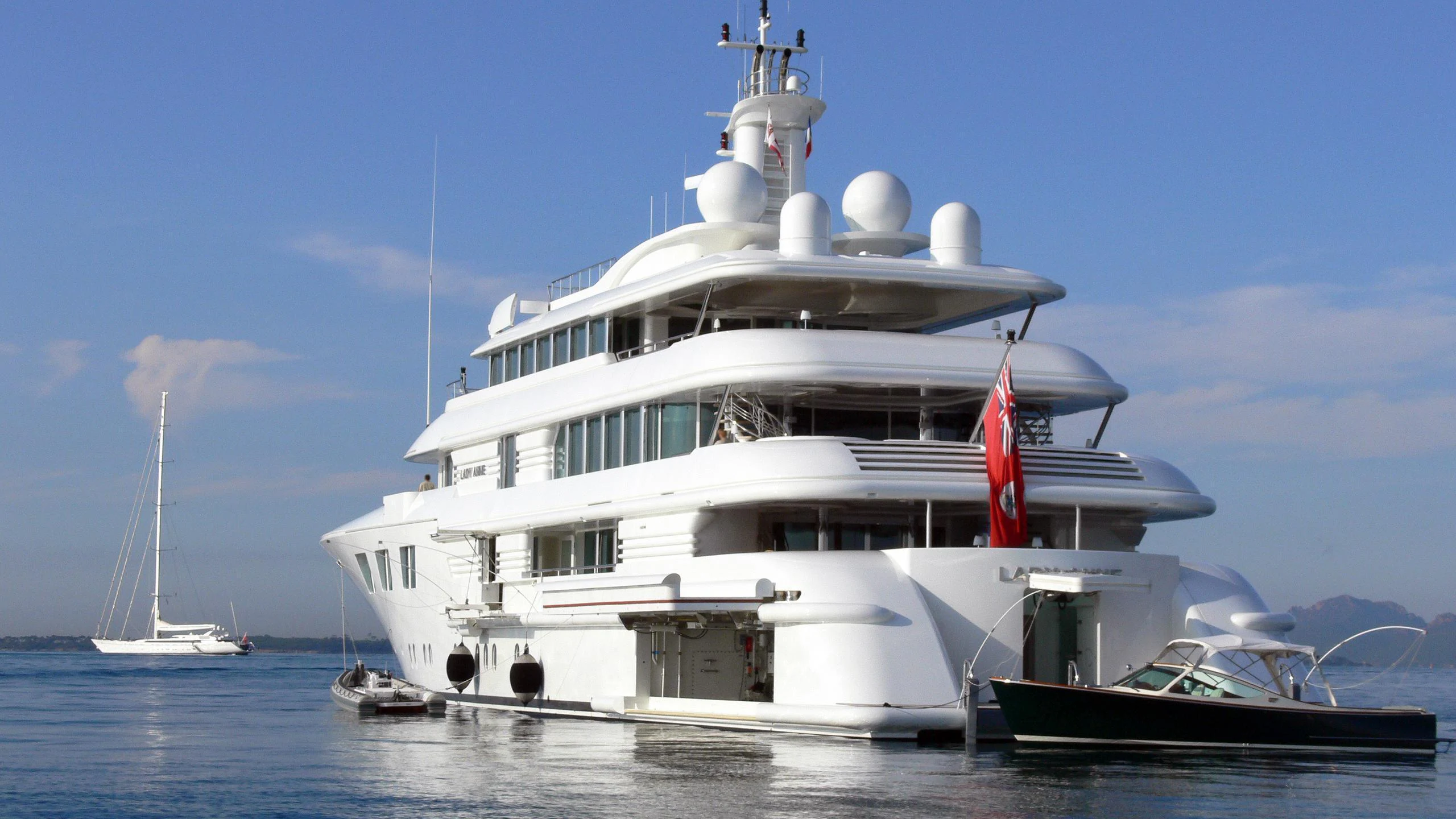 a large white boat with a red stripe on the front aboard LADY E Yacht for Charter