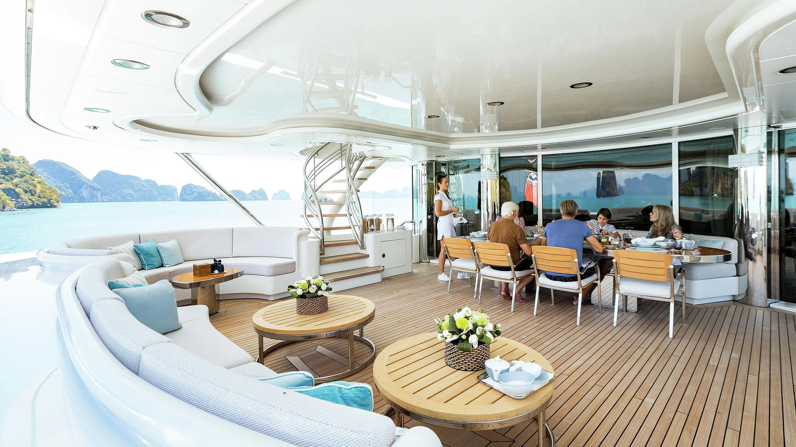 a room with a table chairs and people sitting at it aboard LADY E Yacht for Charter