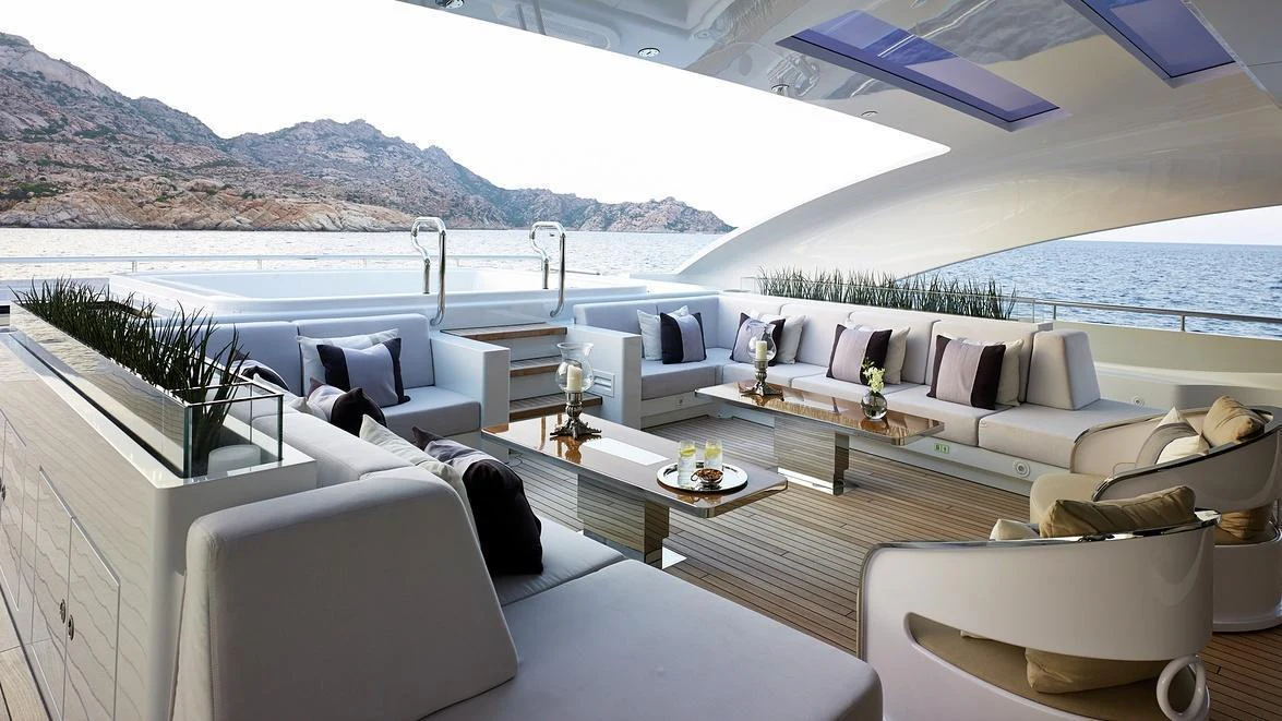 a living room with a large body of water and mountains in the background aboard ILLUSION Yacht for Charter