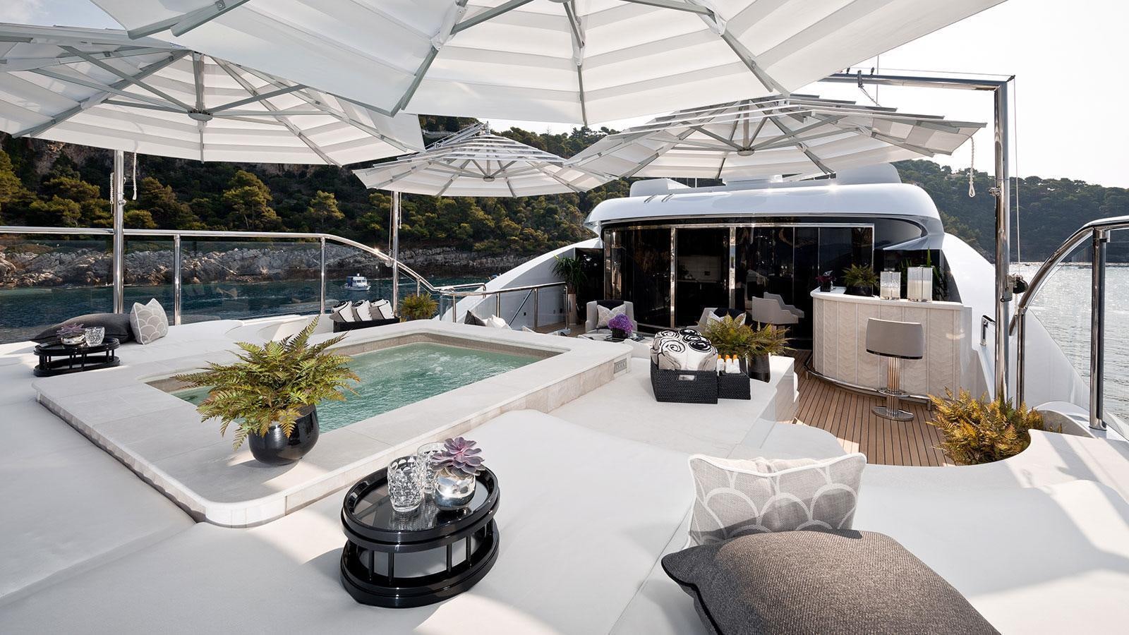 a large white lounge area with a pool and a large white umbrella aboard SOUNDWAVE Yacht for Charter