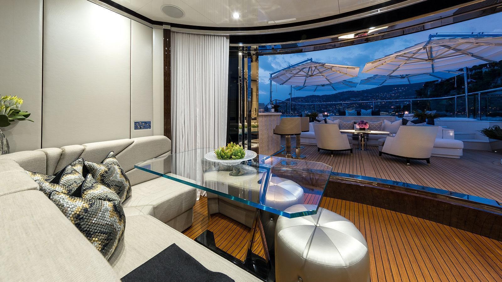 a living room with a large glass table and a large window aboard SOUNDWAVE Yacht for Charter