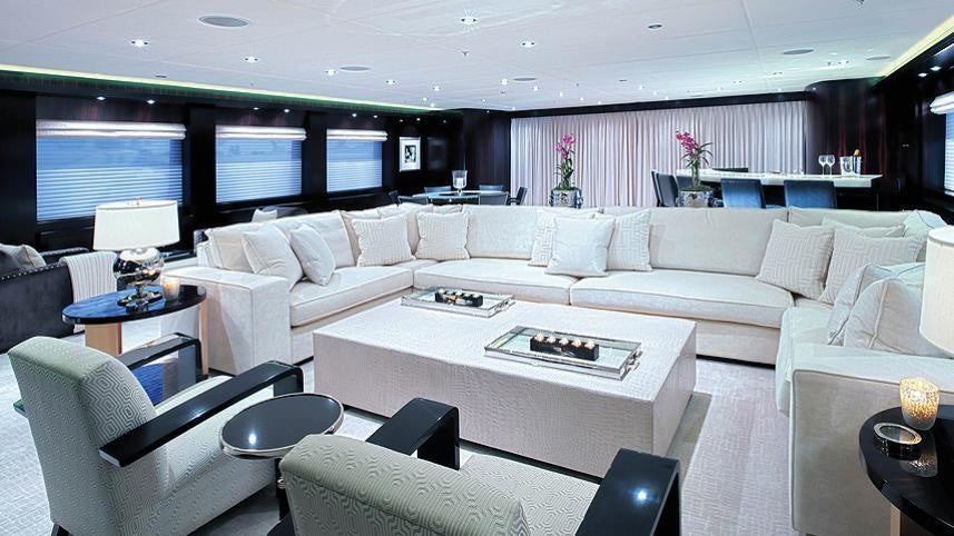 a living room with a large white sofa and a large screen aboard CARPE DIEM Yacht for Charter