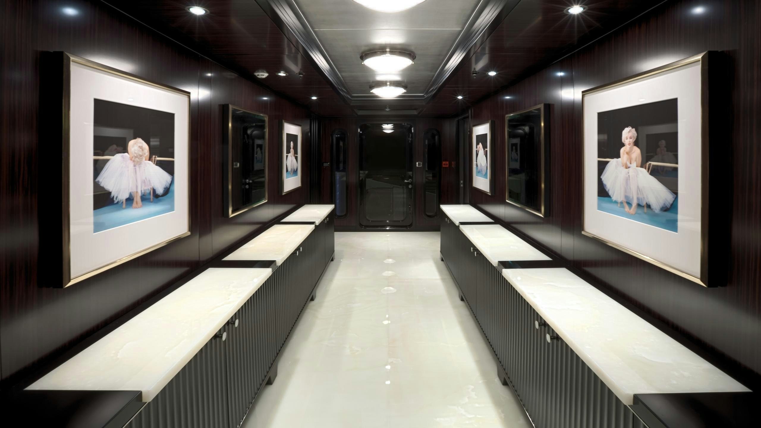 a hallway with several paintings aboard CARPE DIEM Yacht for Charter