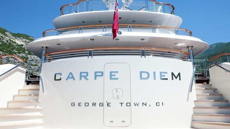 a large white boat with a red ribbon on the front aboard CARPE DIEM Yacht for Charter