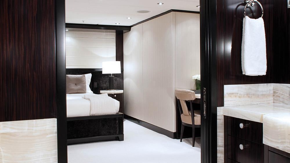 a room with a bed and a chair aboard CARPE DIEM Yacht for Charter