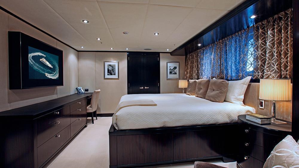 a hotel room with a bed and a television aboard CARPE DIEM Yacht for Charter