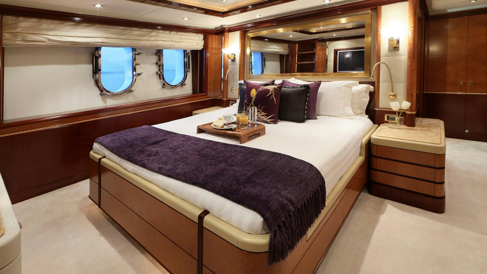 a bed with a blue and white bed spread aboard JAGUAR Yacht for Charter