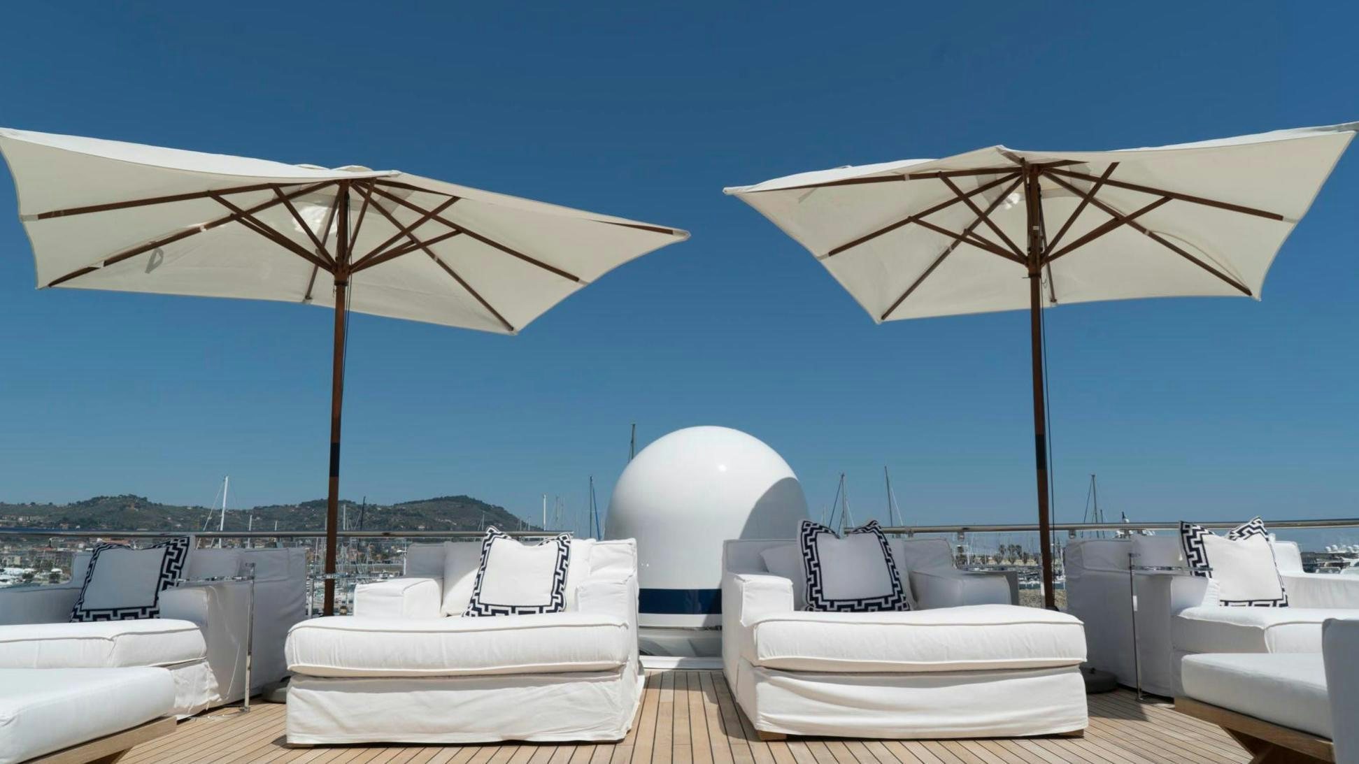 a room with a couple of white beds and umbrellas aboard OCEANA I Yacht for Charter