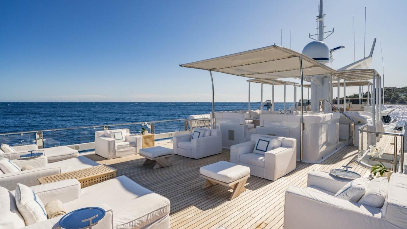 a deck with a view of the ocean and a large white building aboard OCEANA I Yacht for Charter