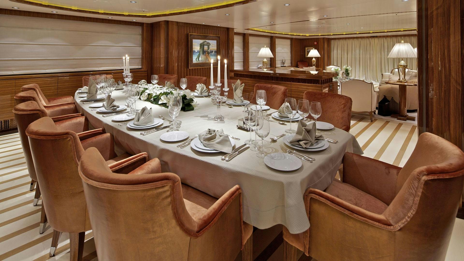 a large dining table with a white tablecloth and chairs aboard MIA RAMA Yacht for Charter