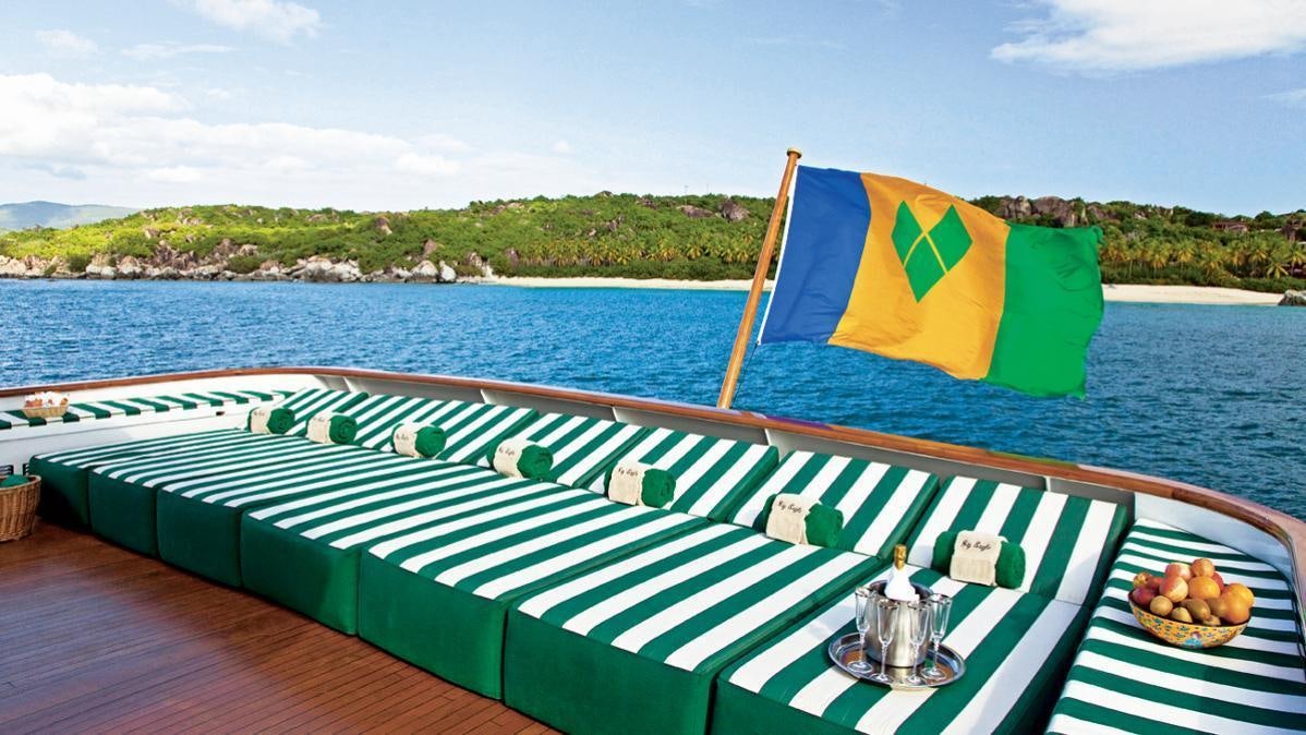 a large green and yellow tent on a deck next to a body of water aboard BIG EAGLE Yacht for Charter