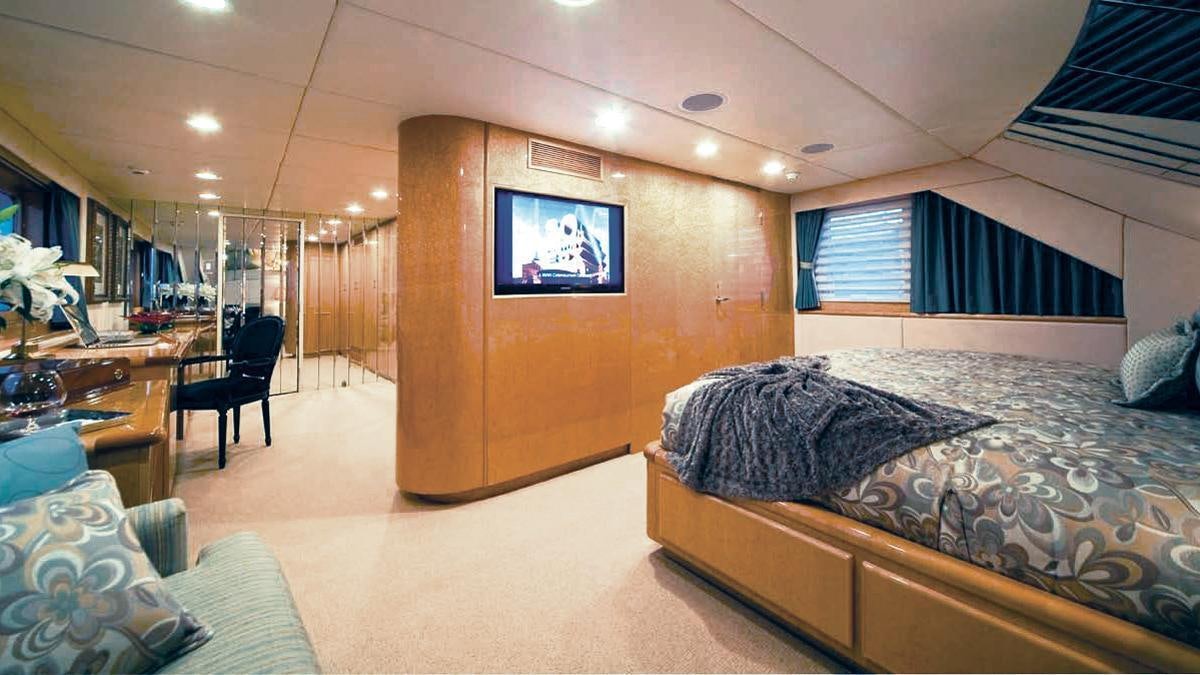 a room with a bed and a tv aboard BIG EAGLE Yacht for Charter