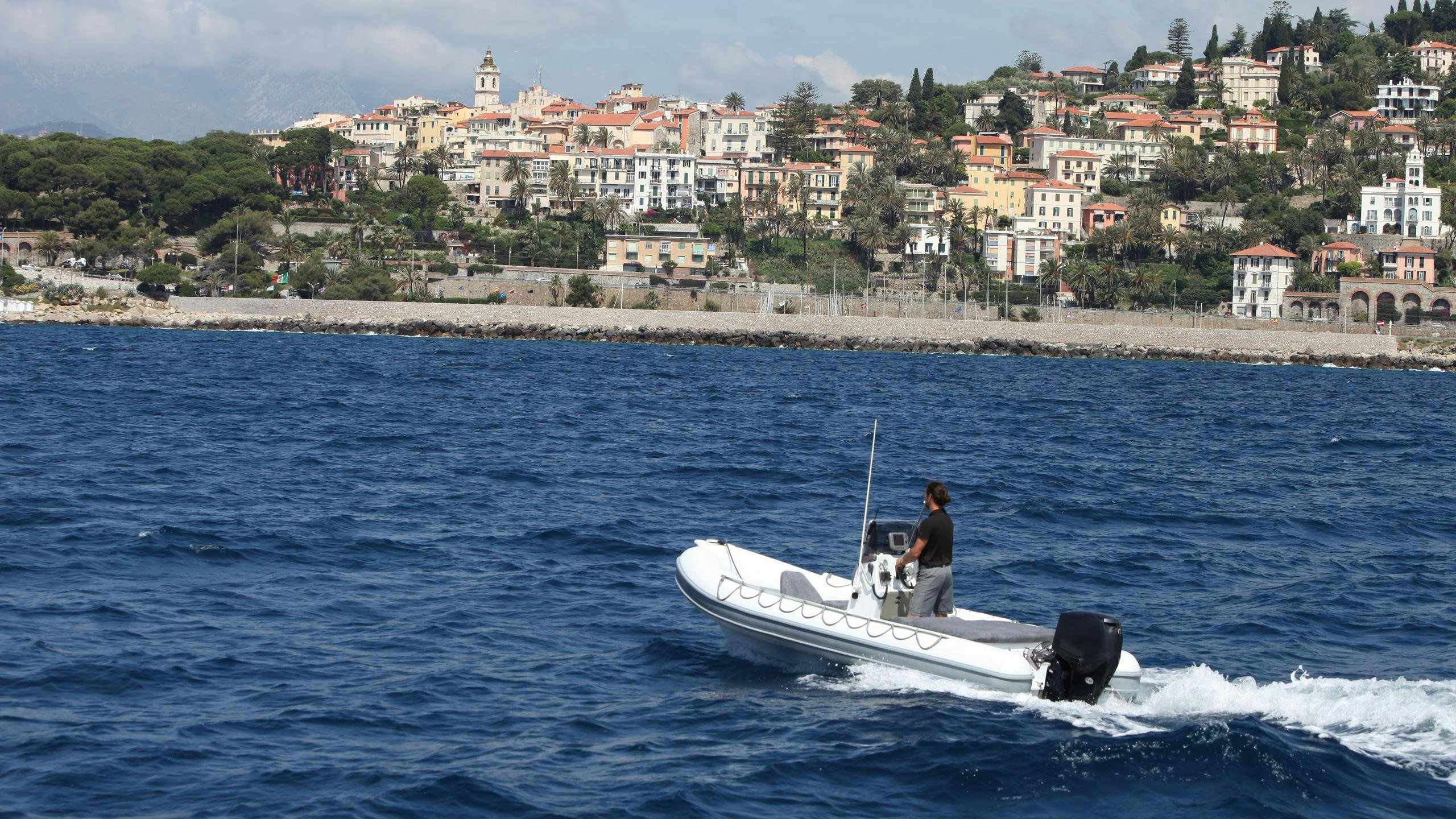 a person driving a boat on the water aboard DIONEA Yacht for Charter