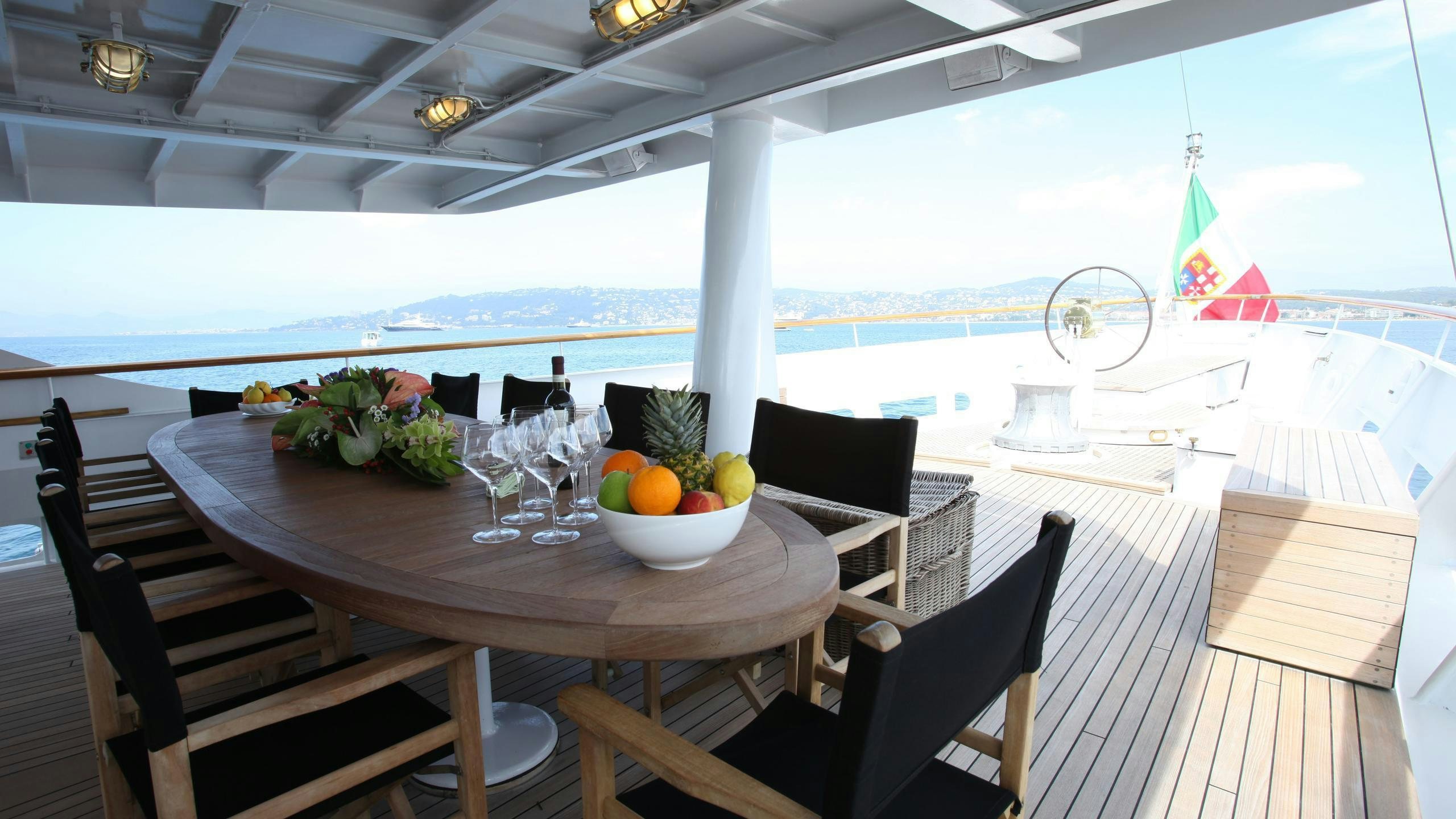 a table with chairs and a bowl of fruit on it aboard DIONEA Yacht for Charter