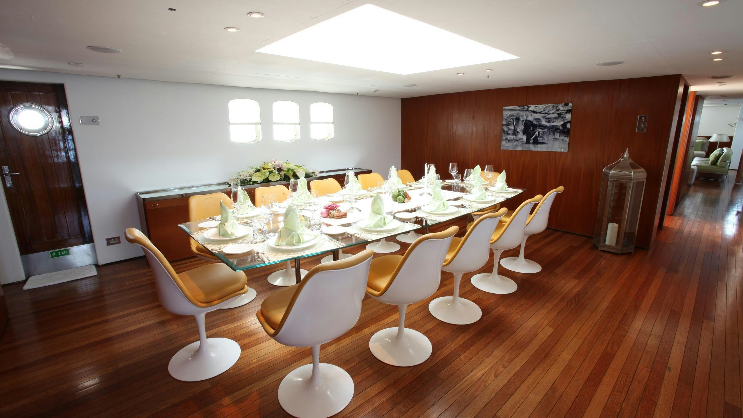 a room with tables and chairs aboard DIONEA Yacht for Charter