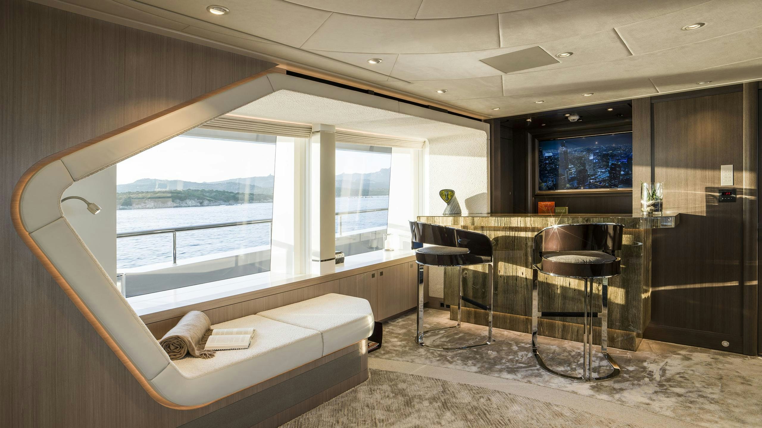 a room with a bed and a table and chairs aboard IRISHA Yacht for Charter