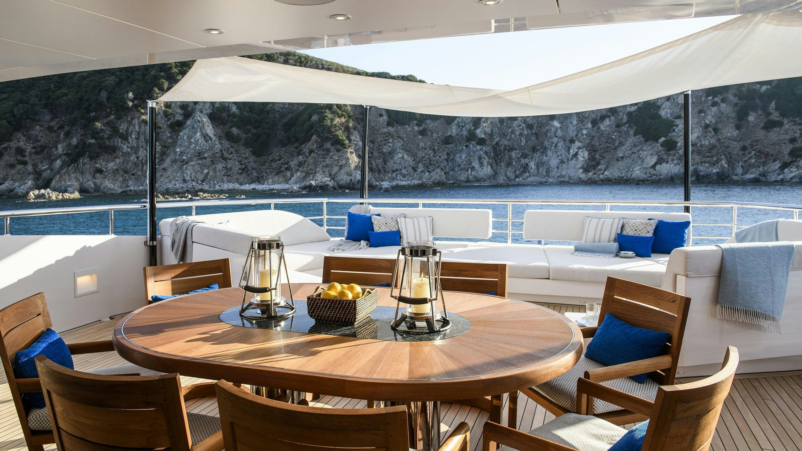 a table with chairs and a large white tent in the background aboard IRISHA Yacht for Charter