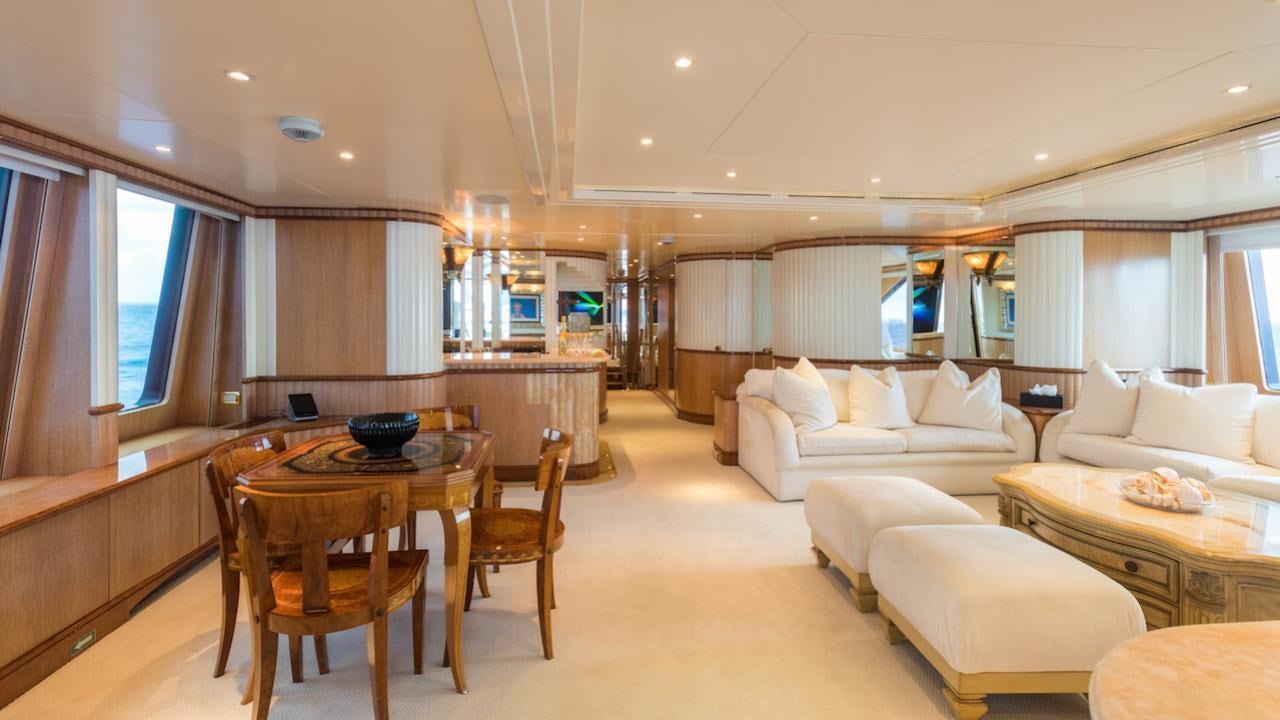 a living room with a large dining table and a large window aboard BARENTS Yacht for Charter