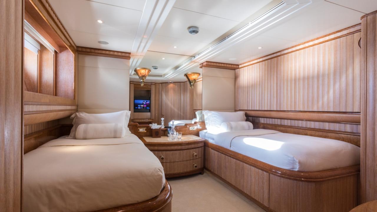 a room with beds and a tv aboard BARENTS Yacht for Charter