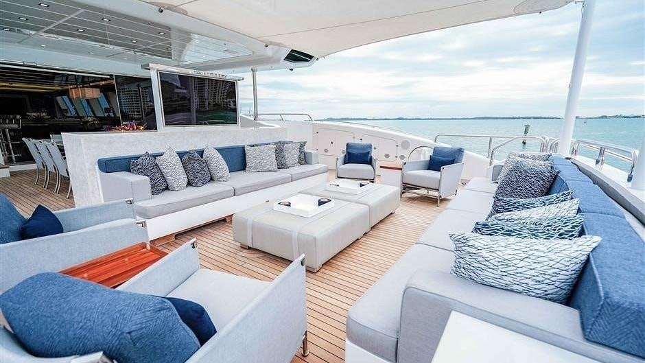 a large white lounge chair next to a large white sofa and a large white sofa in a large aboard (DELETE)INCOGNITO Yacht for Charter