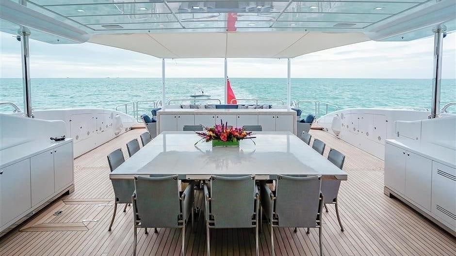 a white table with chairs and a white table with flowers on it aboard (DELETE)INCOGNITO Yacht for Charter