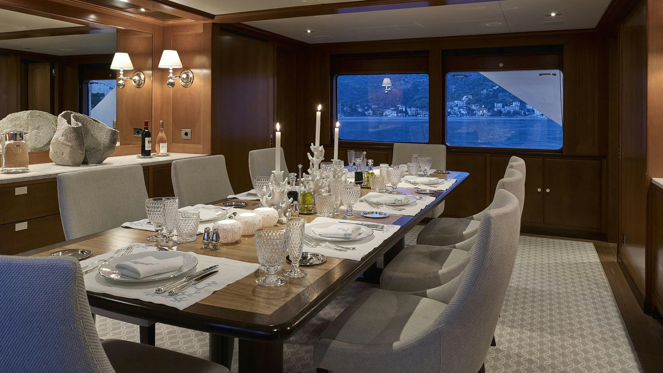 a dining table with a large white tablecloth and chairs aboard ANCALLIA Yacht for Charter