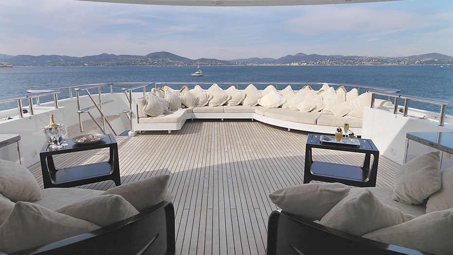 a deck with a view of the ocean and mountains aboard MY LITTLE VIOLET Yacht for Charter