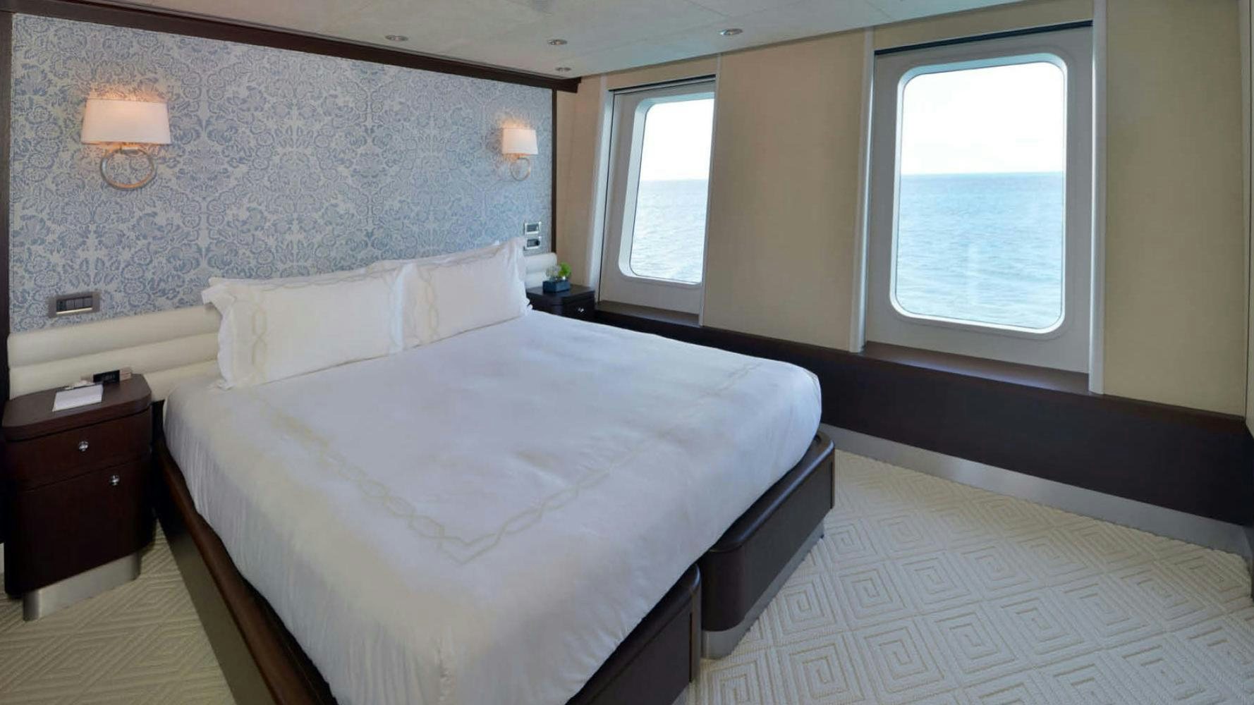 a bed with white sheets aboard BELLA Yacht for Charter