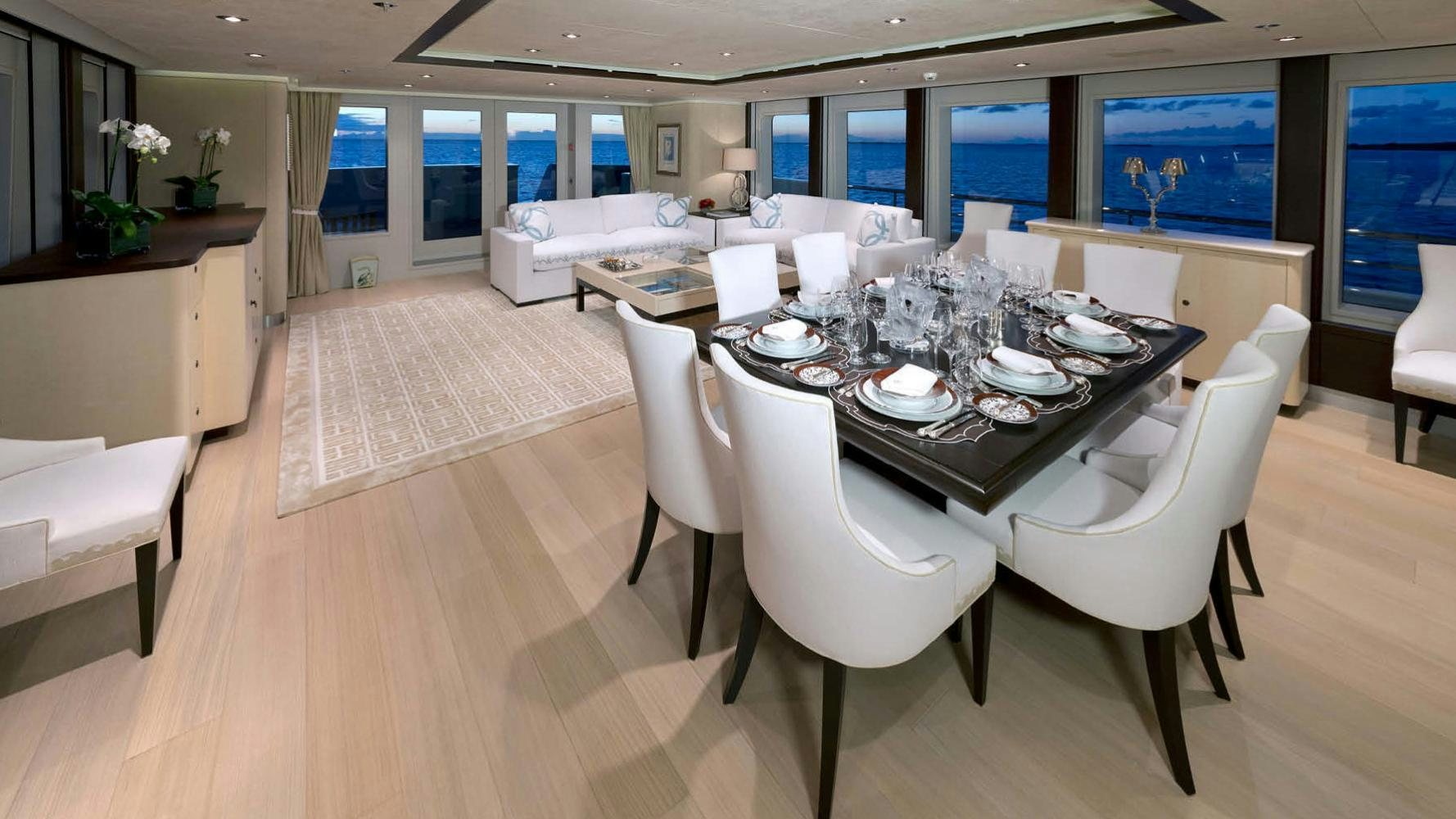 a large white table with plates and chairs aboard BELLA Yacht for Charter
