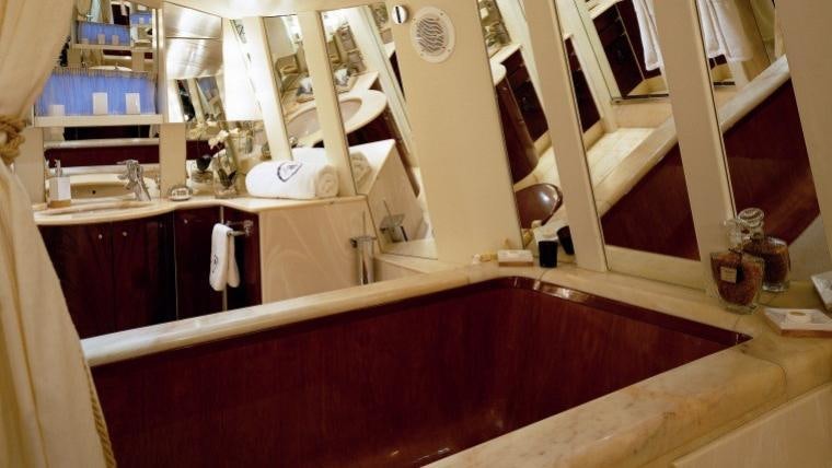 a bathroom with a tub sink and cabinets aboard COSTA MAGNA Yacht for Charter