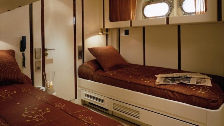 a bed with a red comforter aboard COSTA MAGNA Yacht for Charter