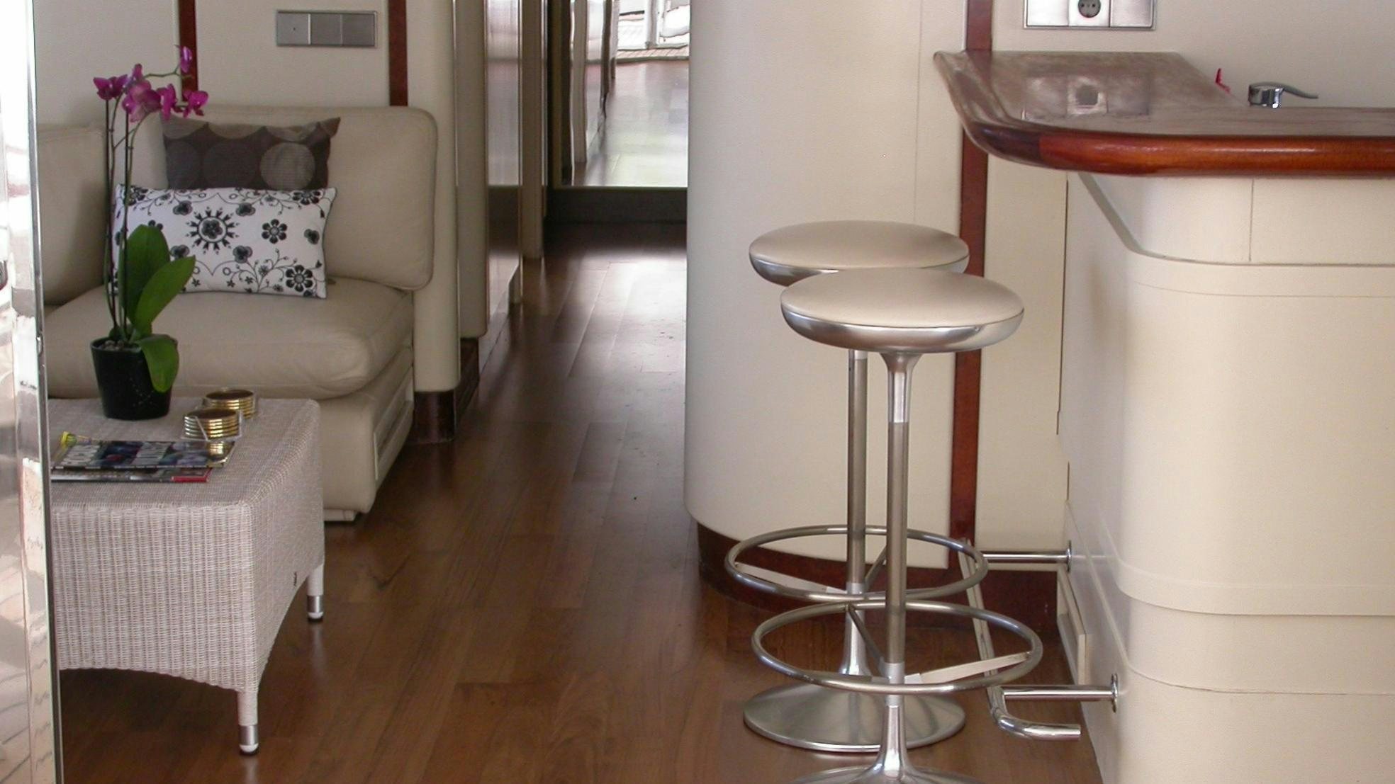 a room with a couch and a table and a chair aboard COSTA MAGNA Yacht for Charter