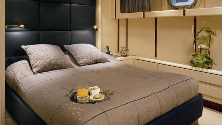 a bed with a tray of food aboard COSTA MAGNA Yacht for Charter