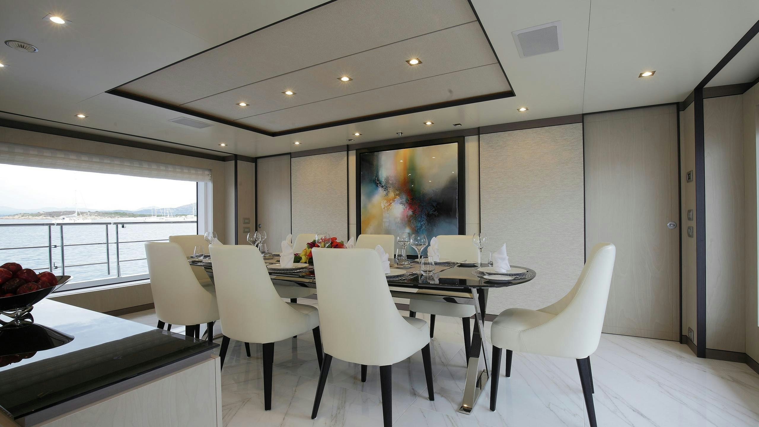 a room with white chairs and a table with white chairs aboard WILLOW Yacht for Charter