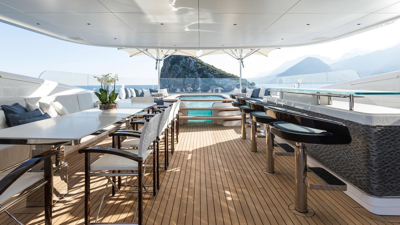 a room with a table chairs and a plant on the side aboard RUYA Yacht for Charter