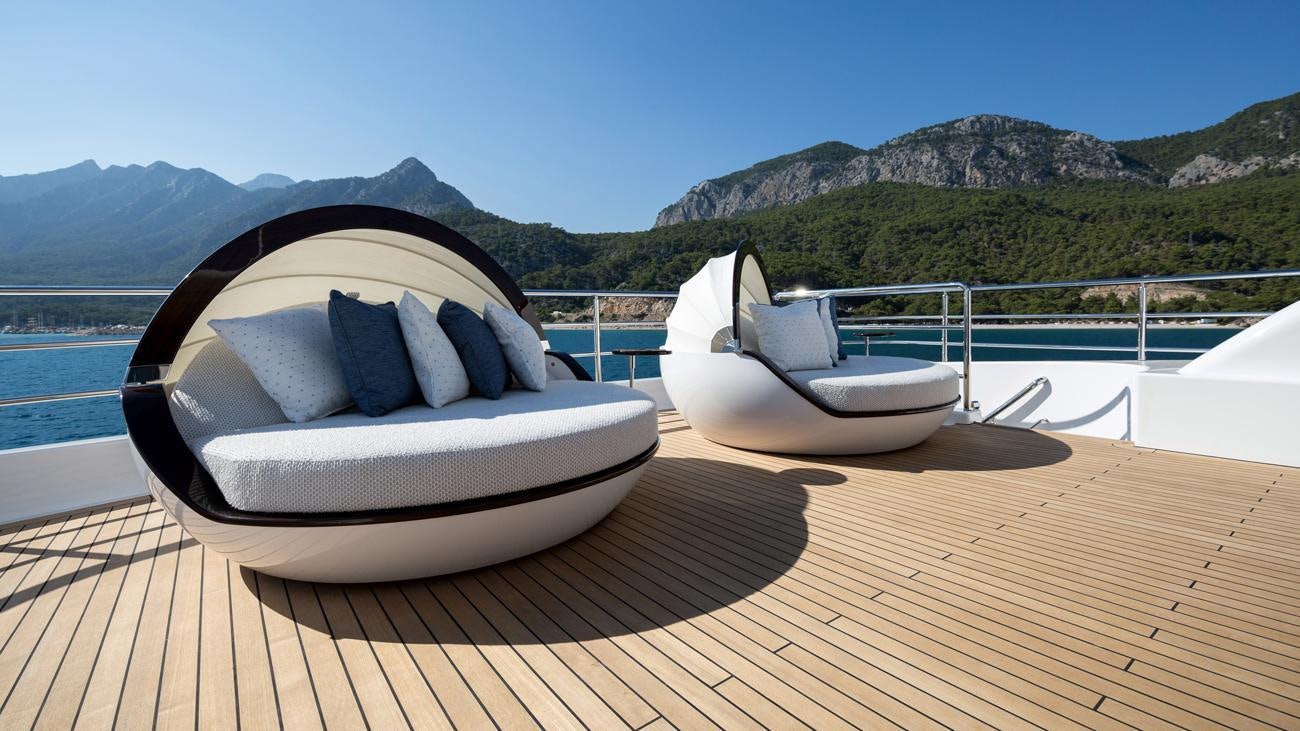 a white chair on a deck overlooking a body of water aboard RUYA Yacht for Charter