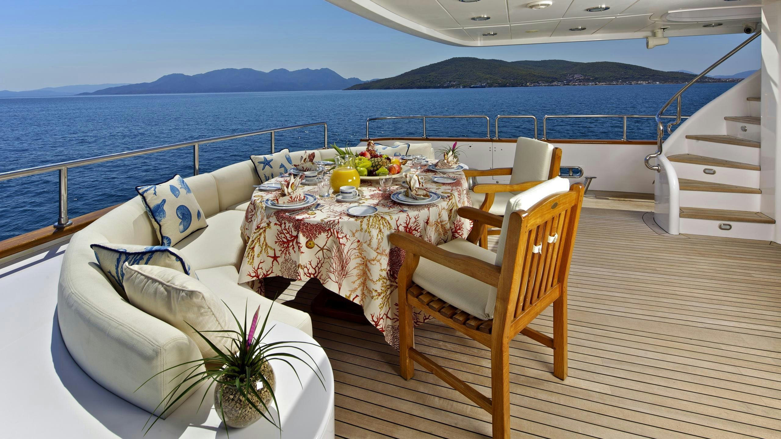 a table set on a deck overlooking the ocean aboard O'RION Yacht for Charter