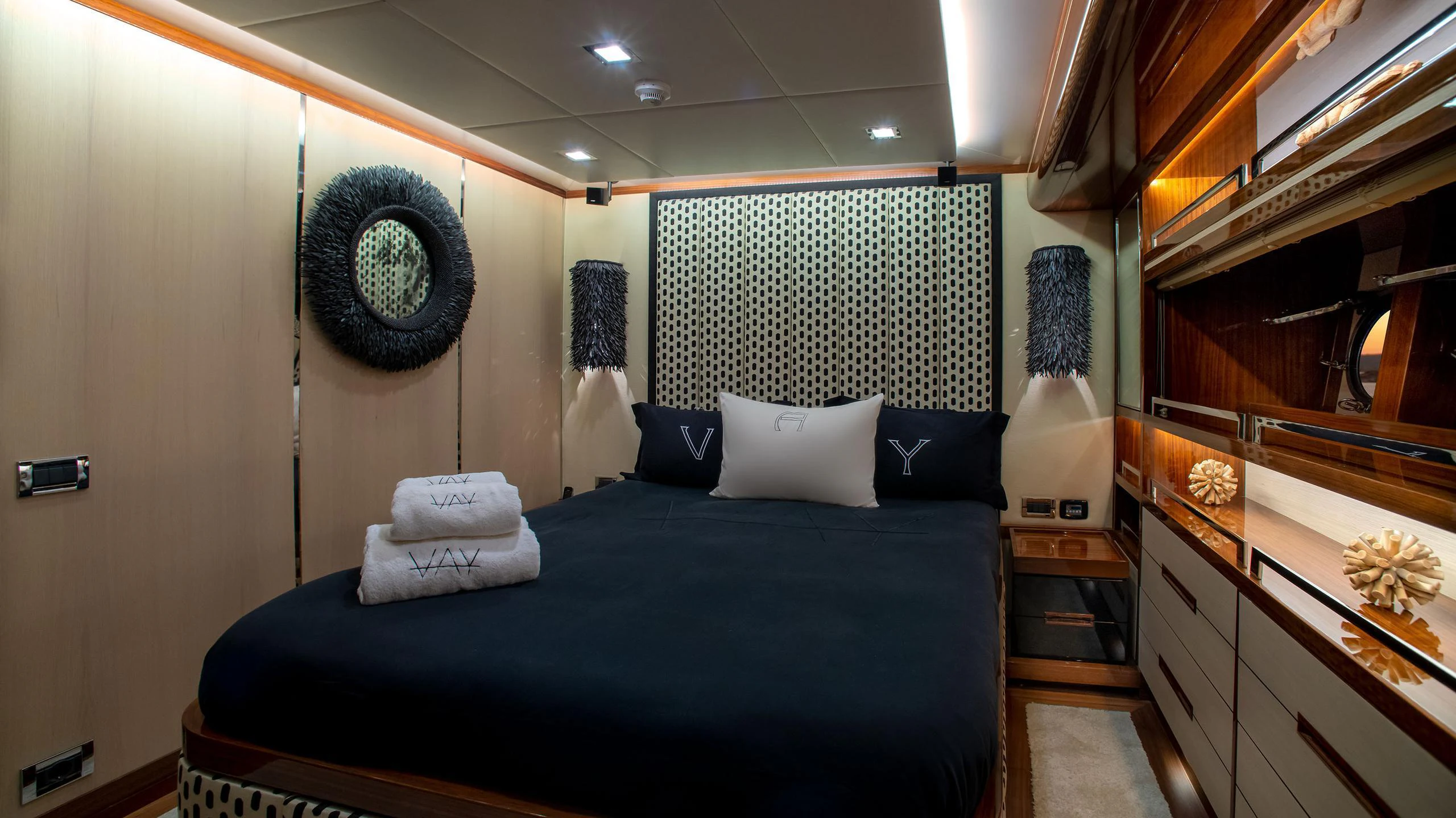 a bedroom with a bed and a mirror aboard VAY Yacht for Charter