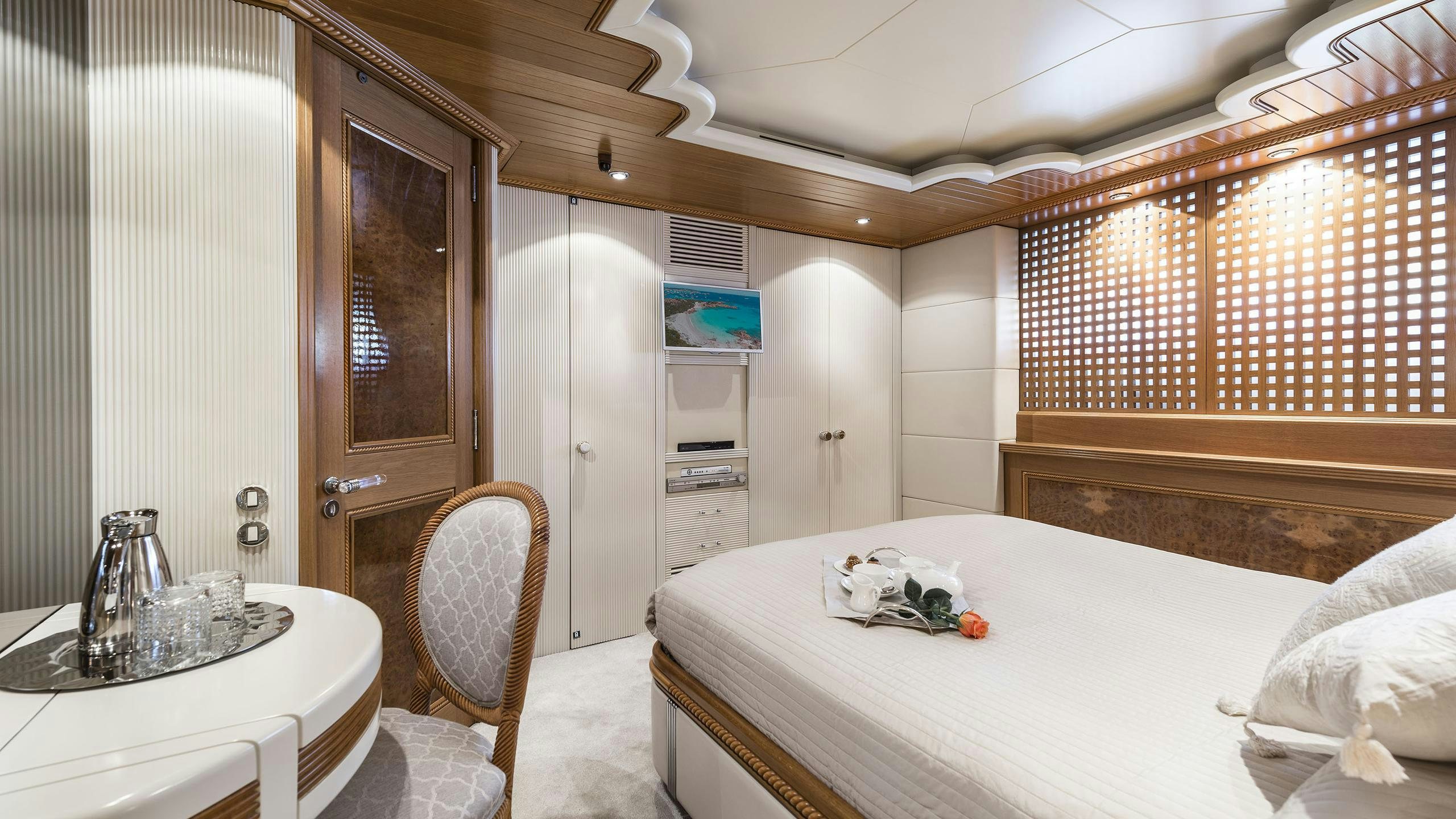 a bedroom with a bed and a table aboard DESAMIS B Yacht for Charter