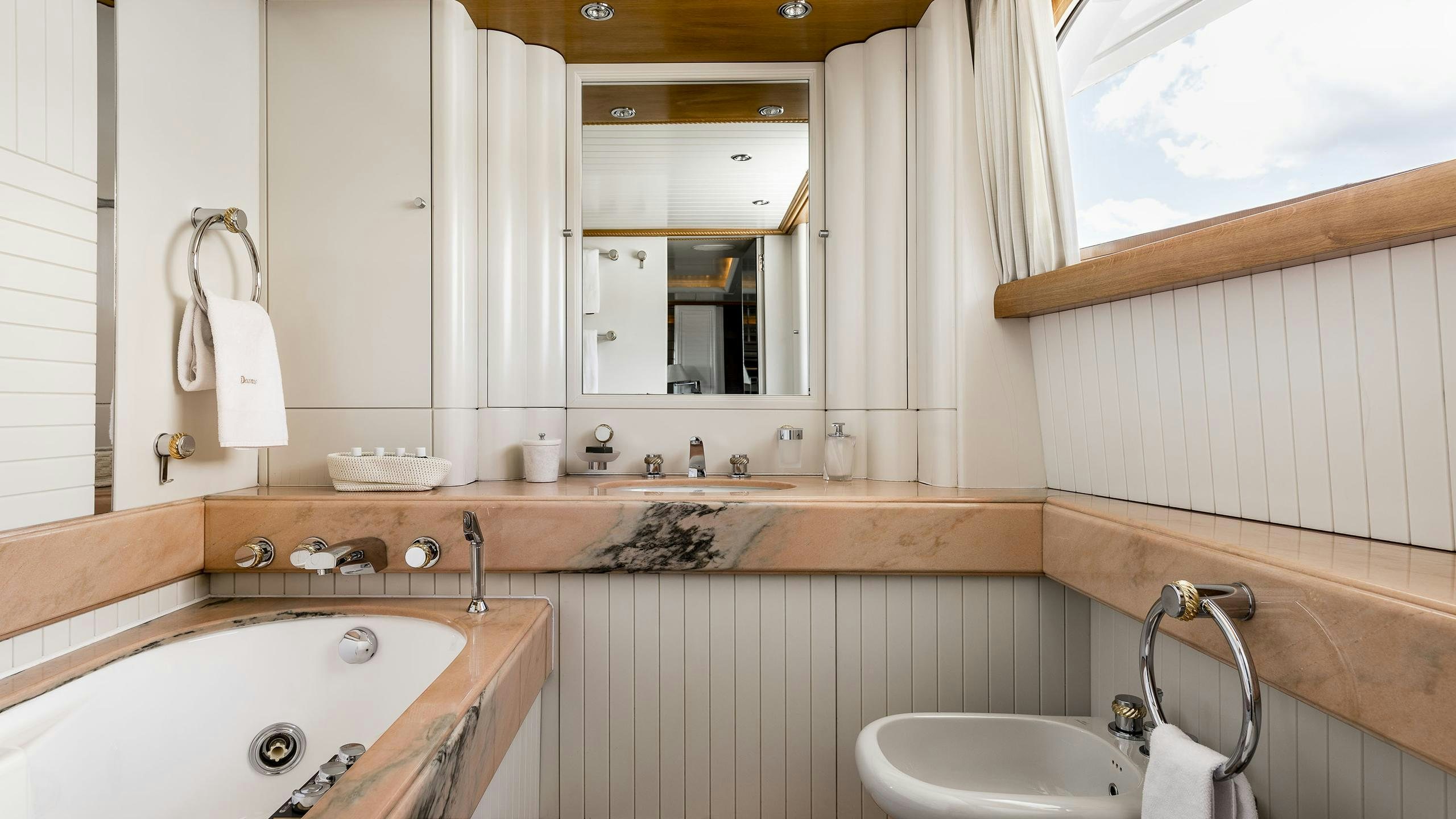 a bathroom with a sink and a mirror aboard DESAMIS B Yacht for Charter