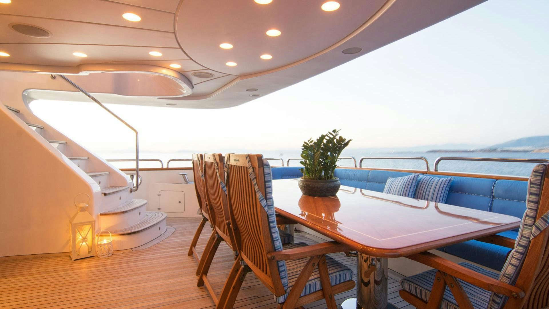 a pool table and chairs in a room with a wood floor and a plant on the table aboard OPTION B Yacht for Charter