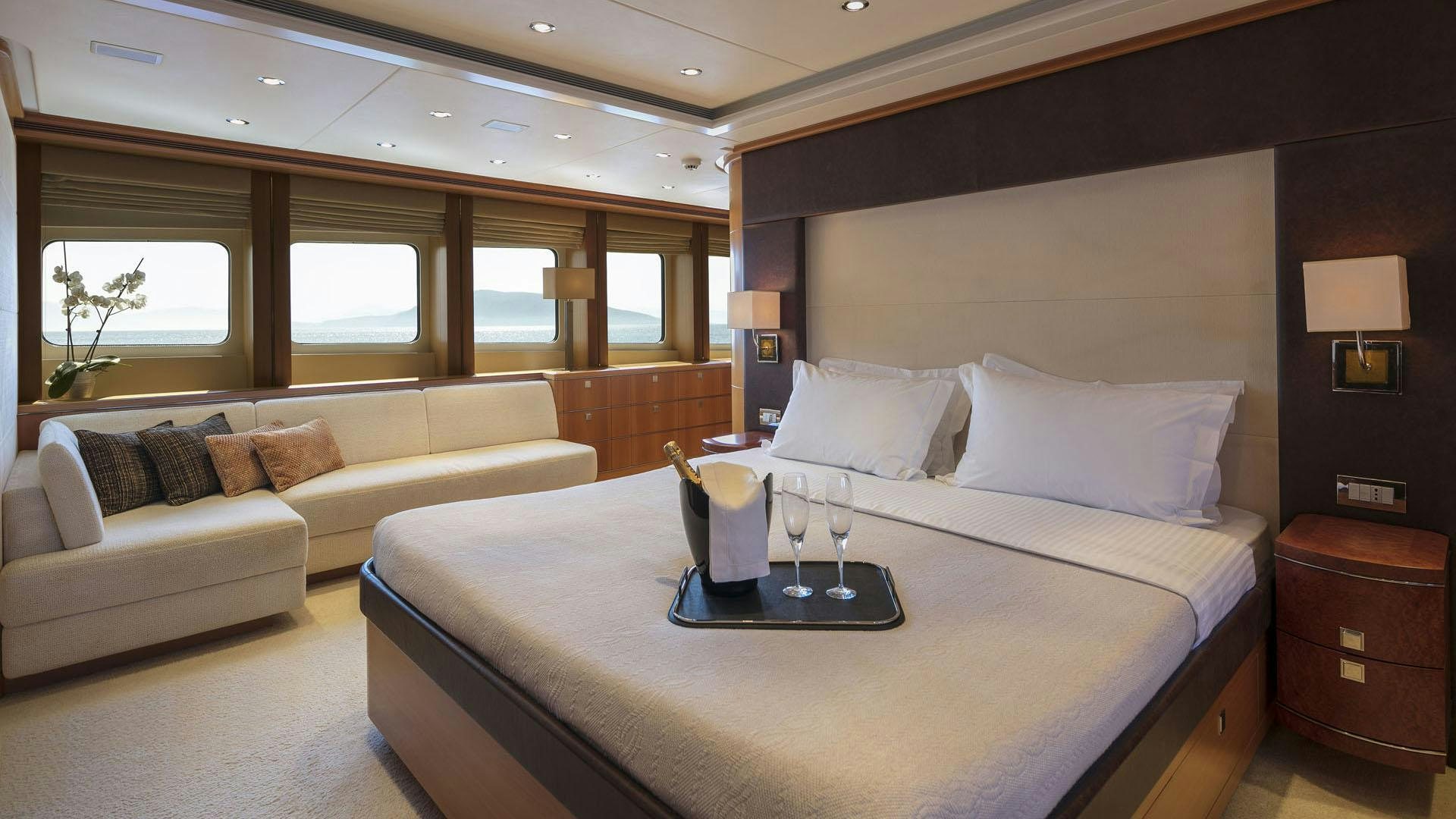 a bed with a white bed spread aboard L'EQUINOX Yacht for Charter
