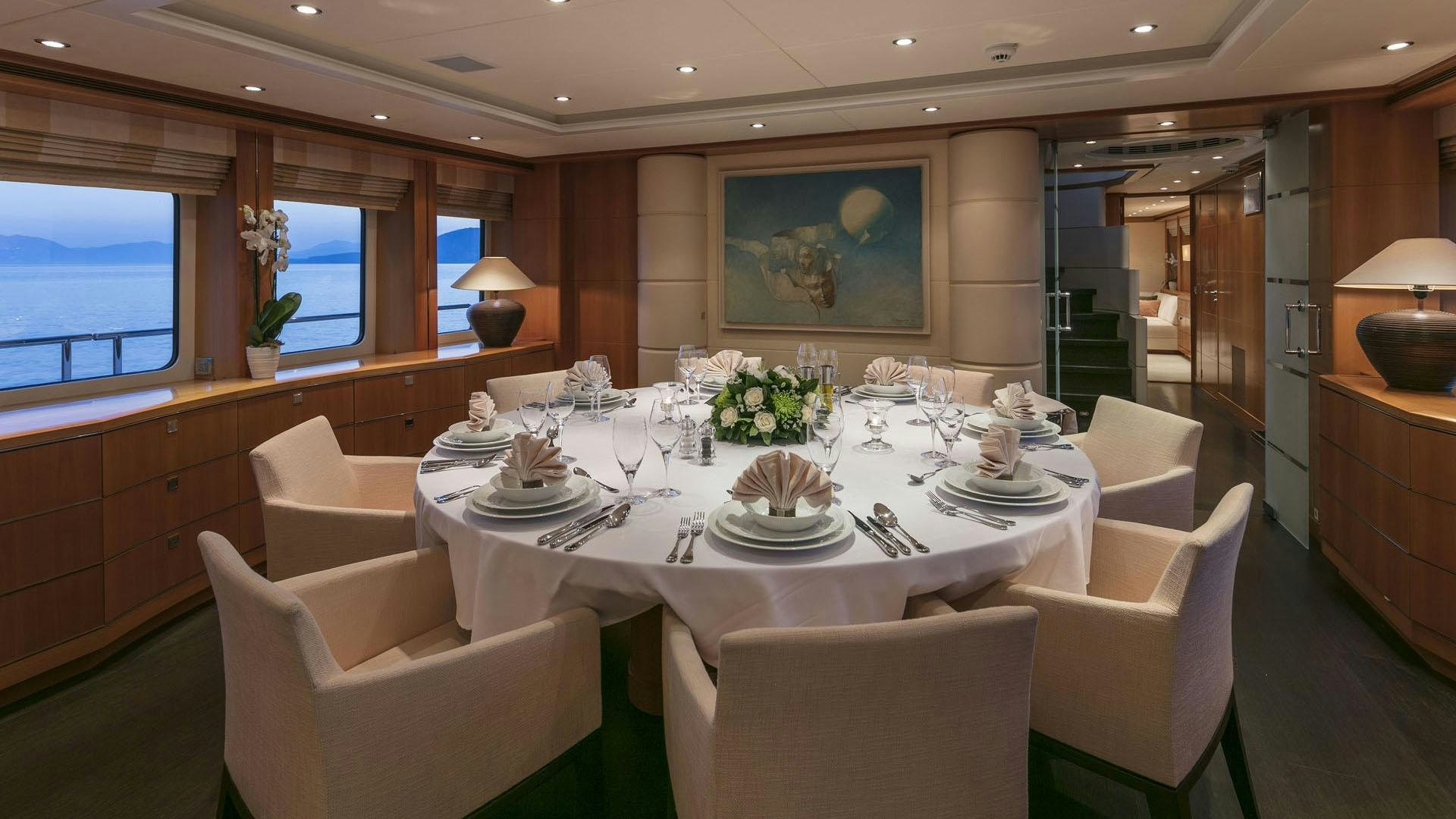 a dining room with a table set aboard L'EQUINOX Yacht for Charter