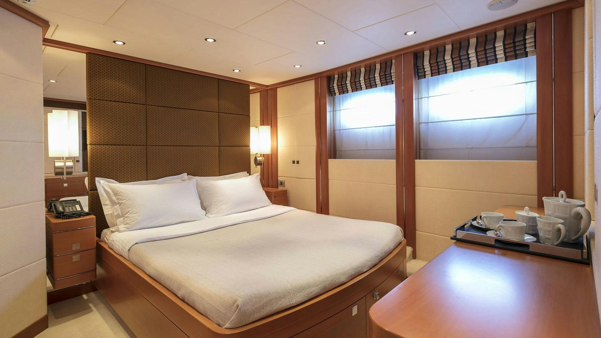 a room with a bed and a desk aboard L'EQUINOX Yacht for Charter