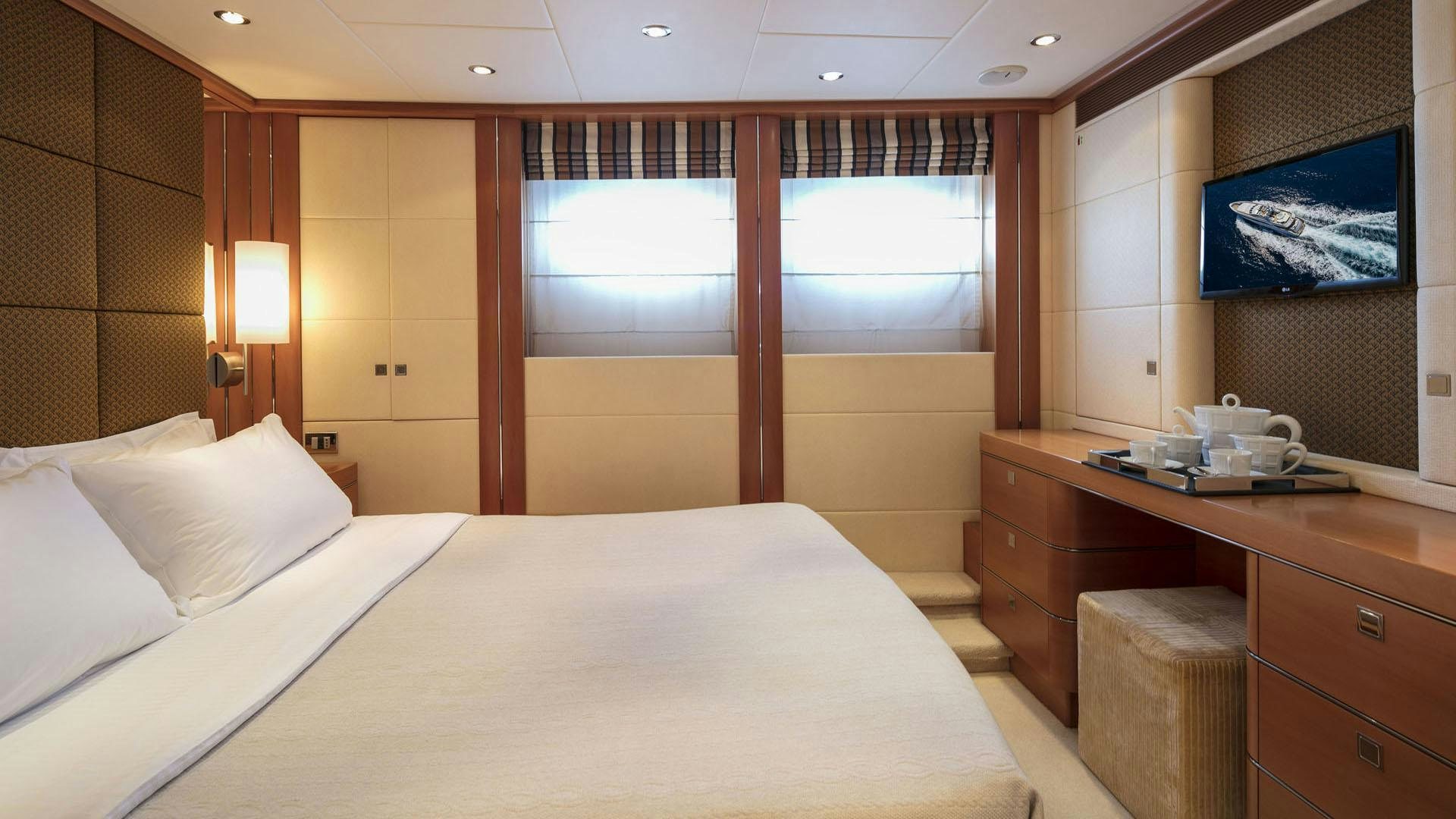 a room with a bed and a desk aboard L'EQUINOX Yacht for Charter